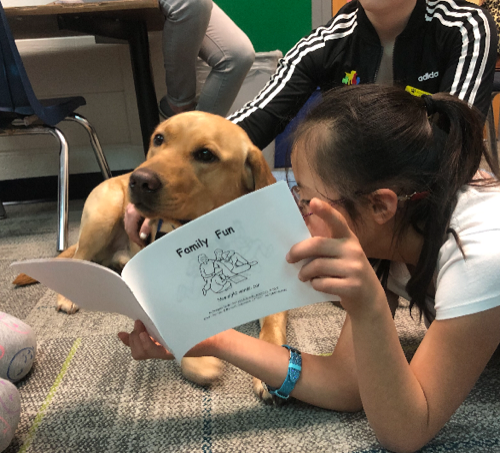A student hugging a facility dog